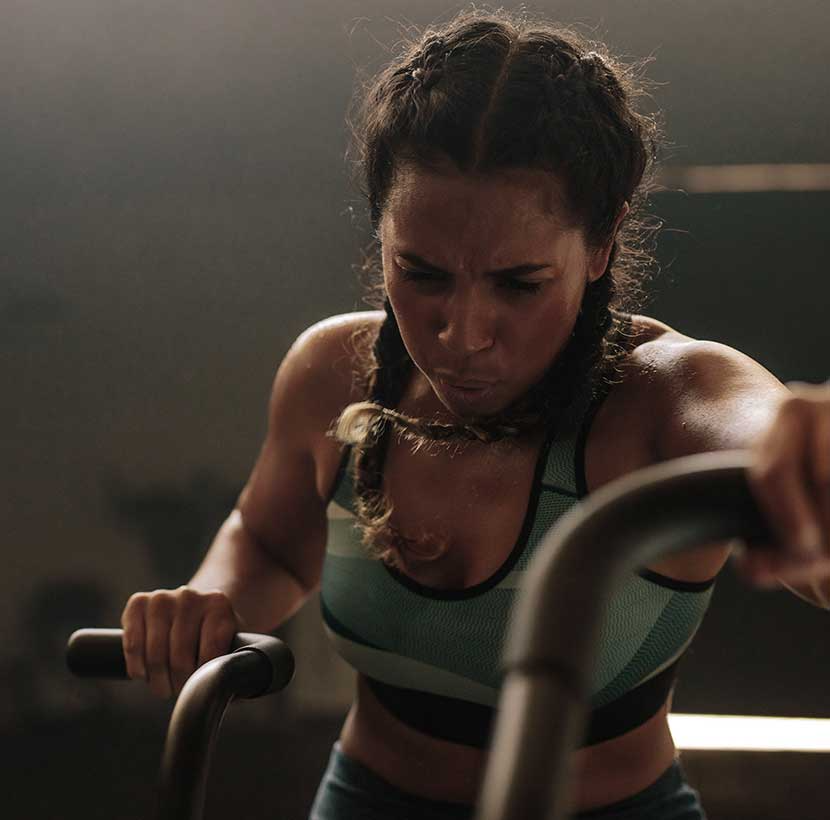 Mulher a fazer um exercício de alta intensidade. Os estudos dizem que o exercício de alta intensidade te ajuda a ter um coração em forma. Mas fá-lo com segurança. Nós explicamos-te como